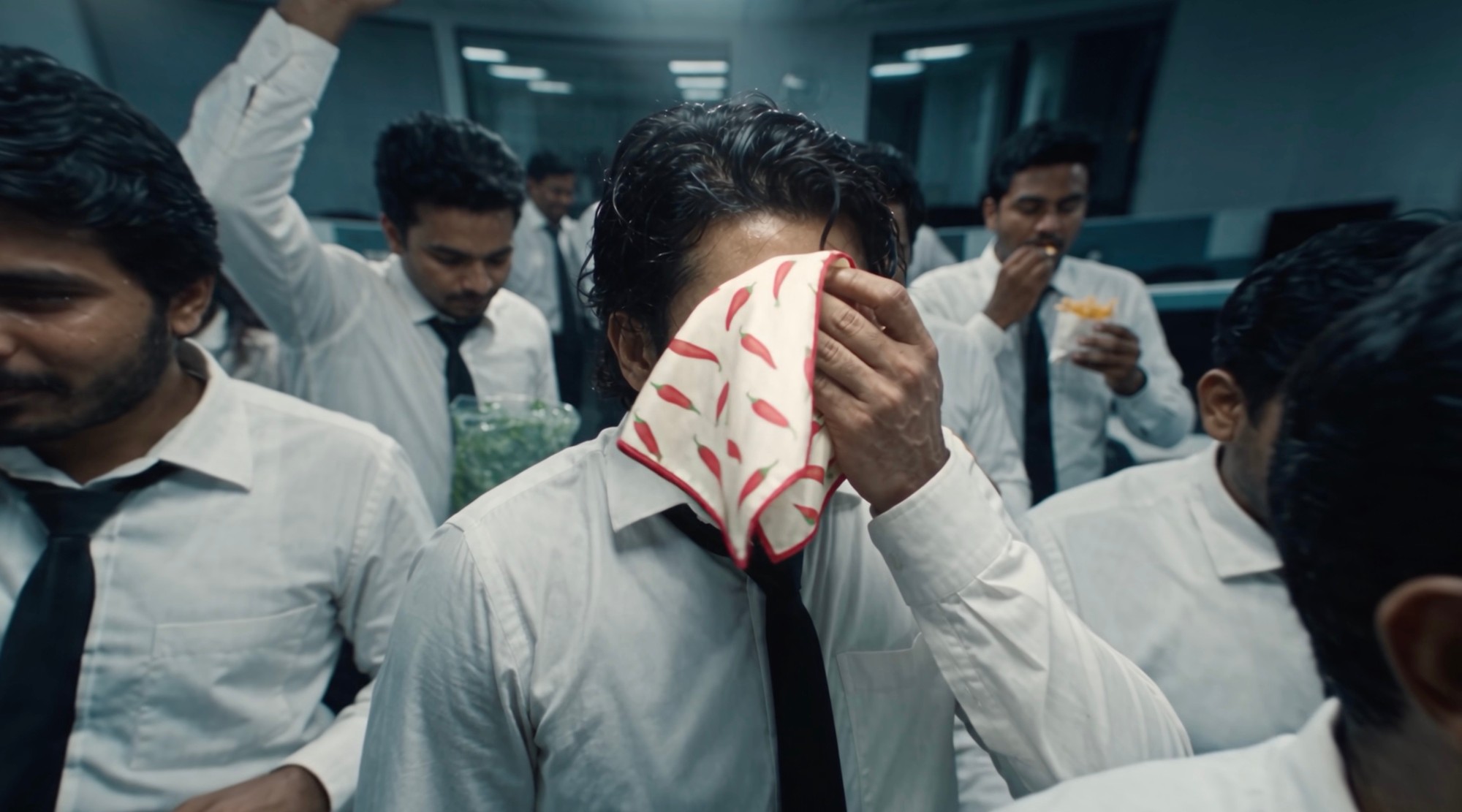 Wiping away chilli sweat with a chilli-print handkerchief