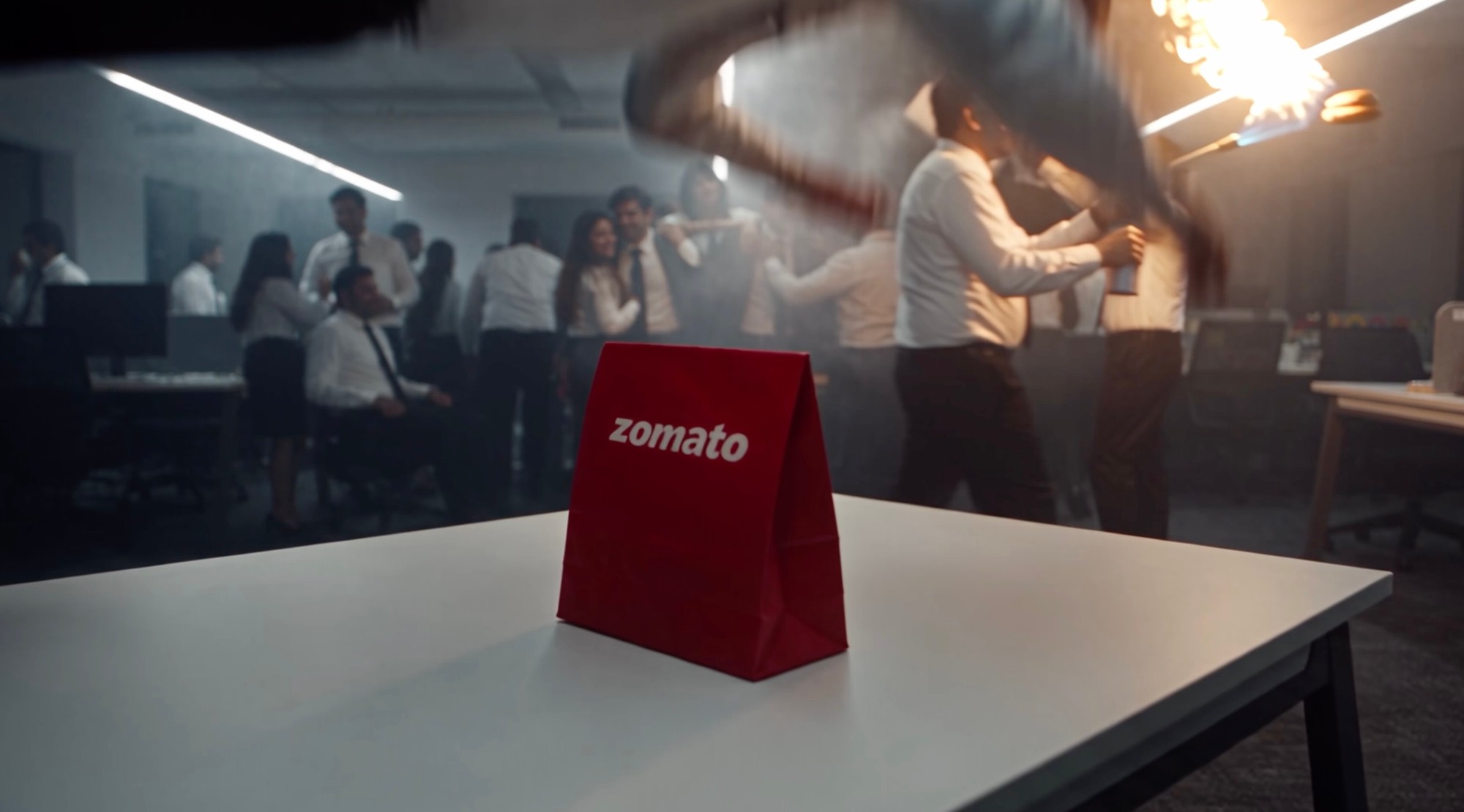 Red against the party: the Zomato bag on the table mid-party