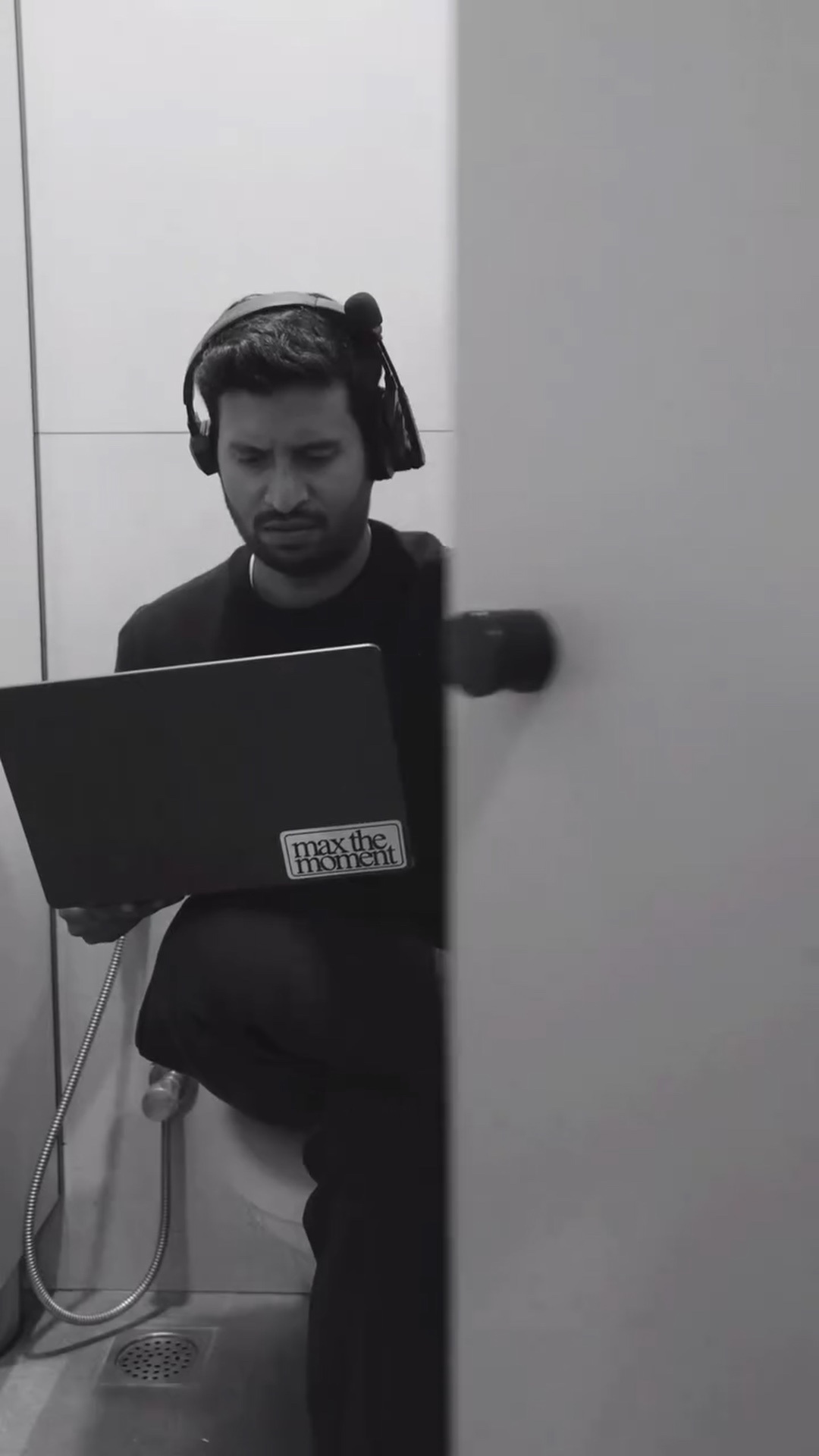 Headphones on and laptop open, hiding out in the washroom